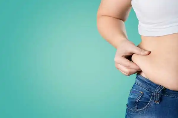 Image of woman pinching her love handles to show weight gain East Retford